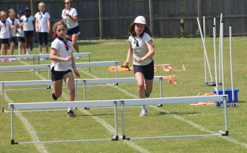 Junior girls jumping hurdles
