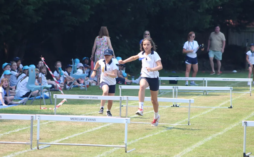 Junior girls jumping hurdles